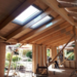 Tagkonstruktion af træ i et nybyggeri, hvor Velux vinduer er monteret for at give naturligt lys til rummet.