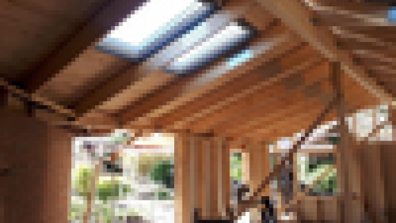 Tagkonstruktion af træ i et nybyggeri, hvor Velux vinduer er monteret for at give naturligt lys til rummet.